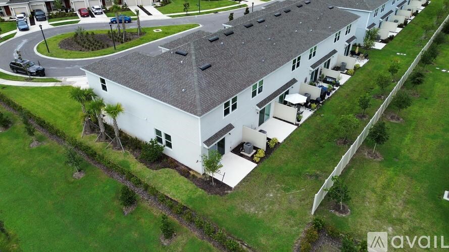 A white building with a grey roof is surrounded by green grass.