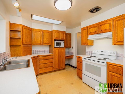 A kitchen with wooden cabinets and white appliances.
