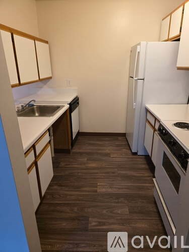 A kitchen with white appliances and wooden cabinets.