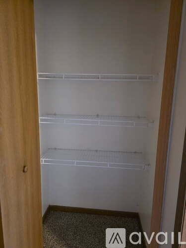 Empty white shelves in a room with a wooden door.