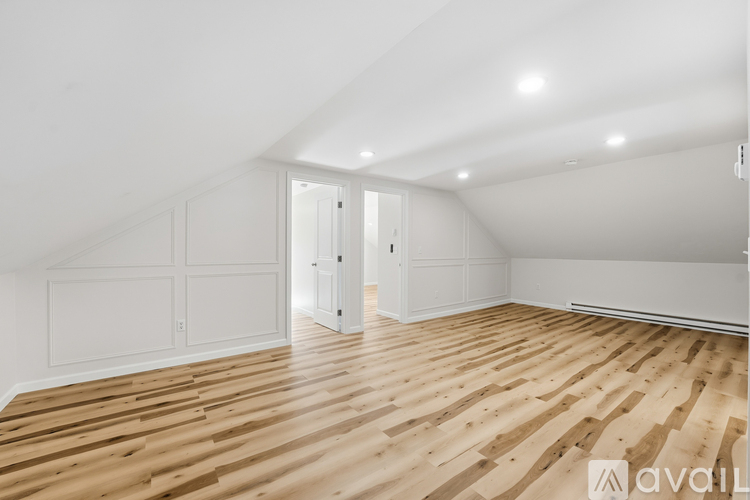 A room with wooden flooring and white walls.