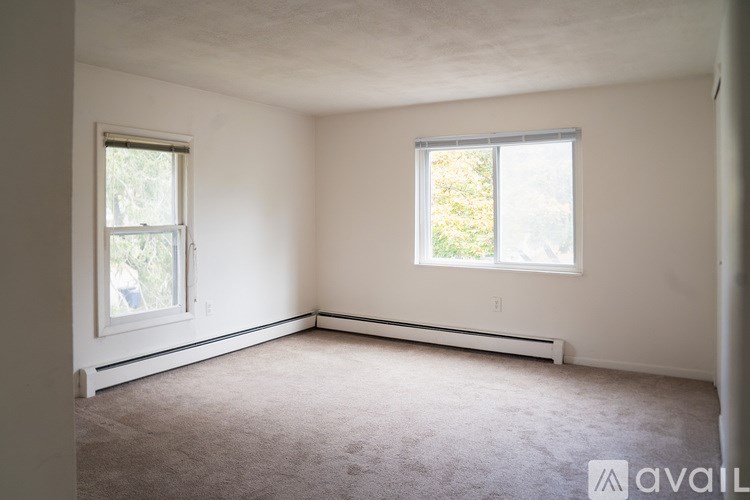 A room with a window and a carpeted floor.