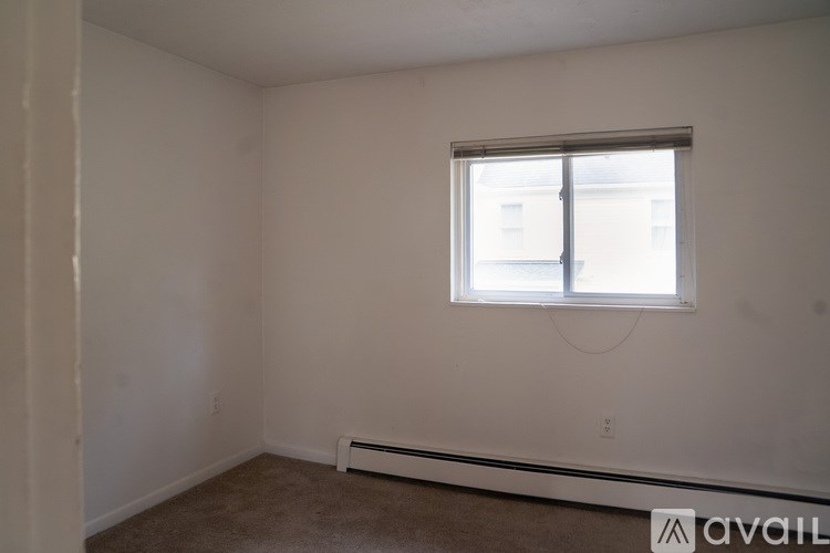 A room with a window and a radiator on the floor.
