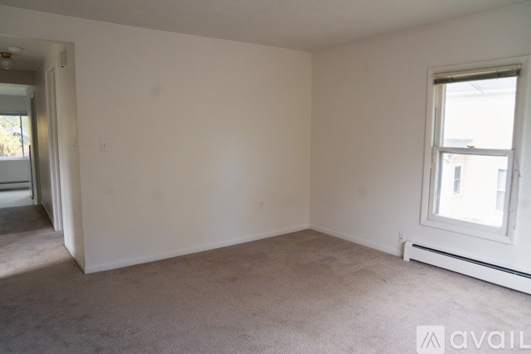 A room with a window and carpeted floor.