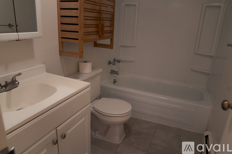 A white bathroom with a toilet, sink, and bathtub.
