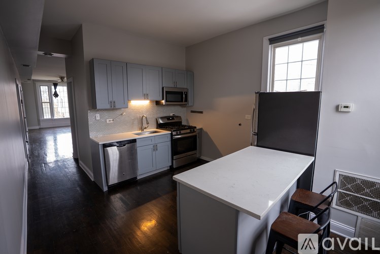 A kitchen with a white counter top and stainless steel appliances.