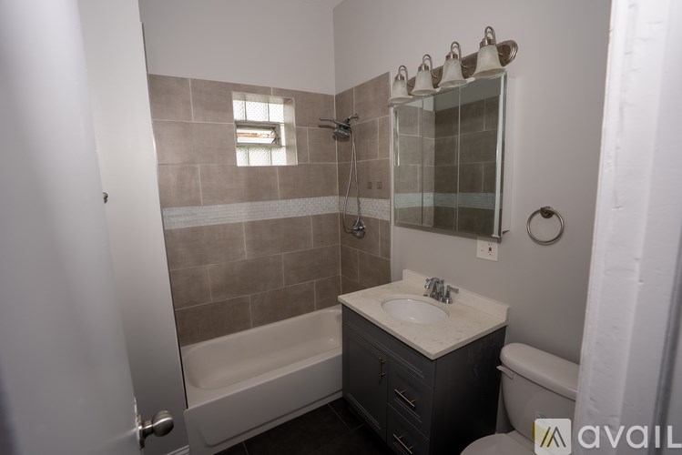 A bathroom with a tub, sink, and mirror.