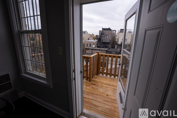 A balcony with a wooden floor and a view of the city.