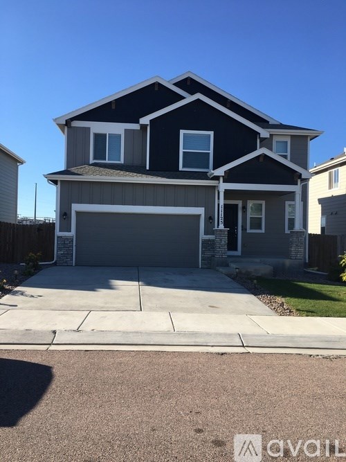 A two-story house with a garage is available for sale.