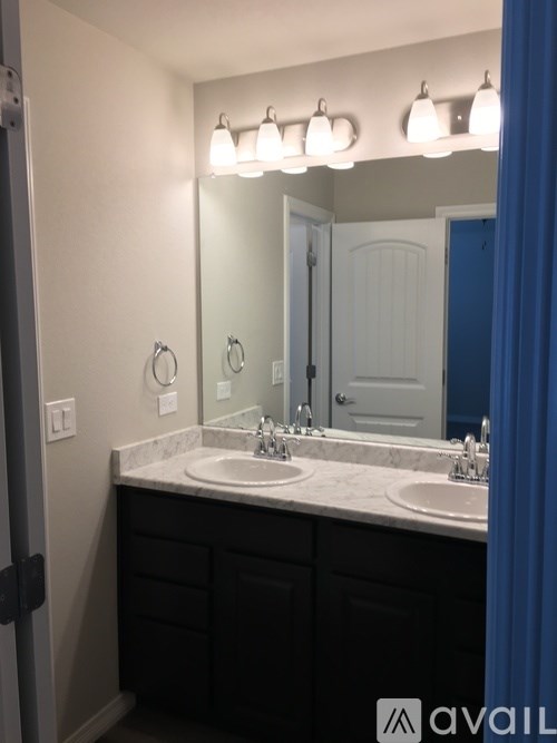 A bathroom with a double sink and a mirror above it.