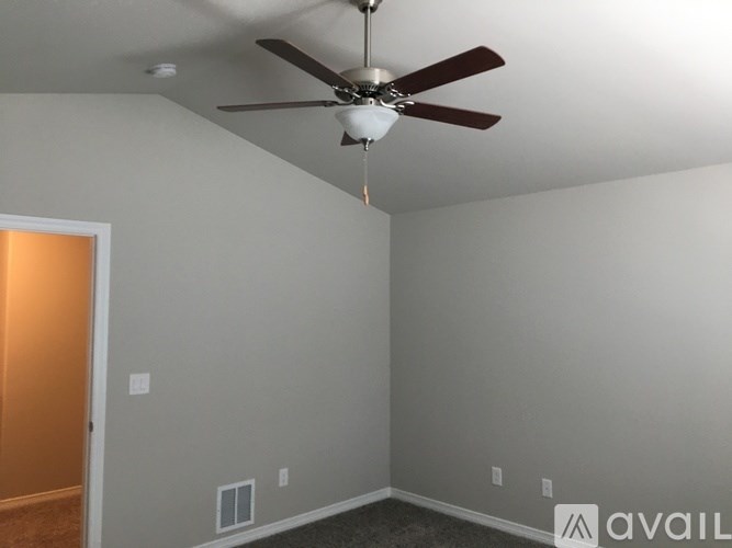 A room with a ceiling fan and a light fixture.