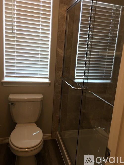 A white toilet sits next to a glass shower door.
