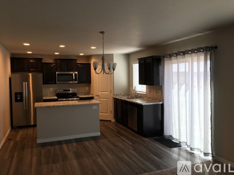 A modern kitchen with dark brown cabinets and a white island.