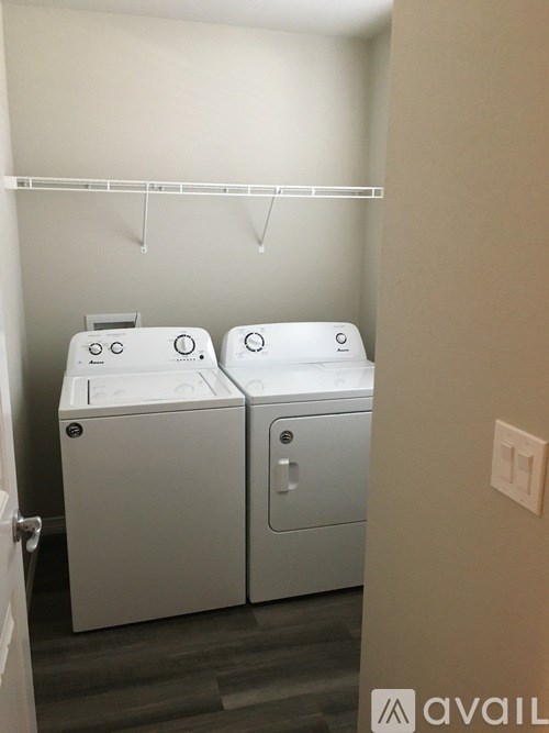 Two white washing machines in a small laundry room.