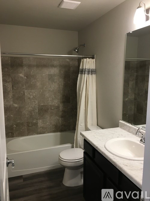 A bathroom with a toilet, sink, and bathtub.