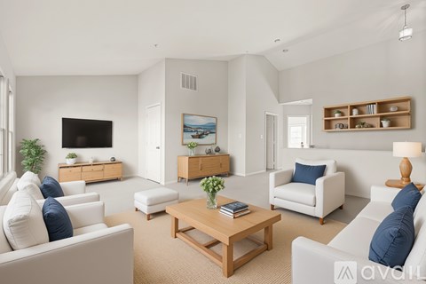A living room with white furniture and a flat screen TV.