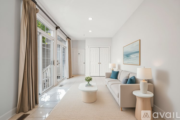 A well-lit, modern living room with a large window, a sofa, and a coffee table.