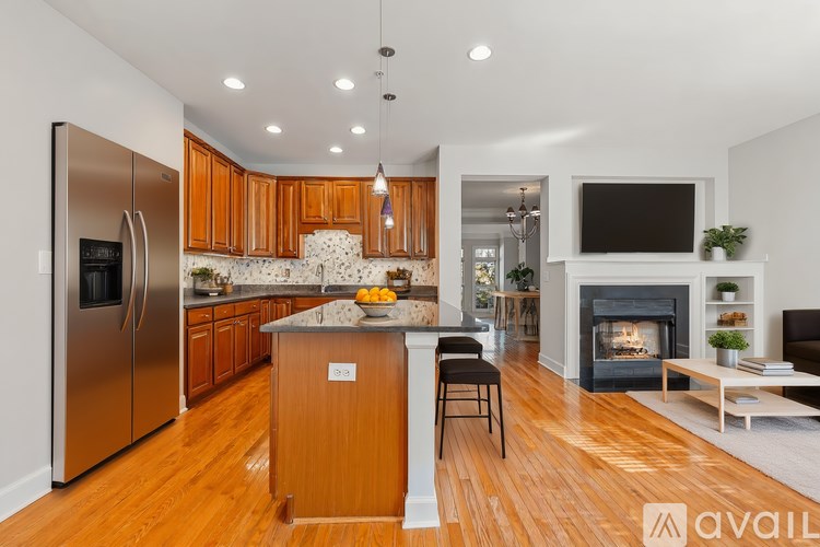 A kitchen with wooden cabinets and a stainless steel refrigerator.