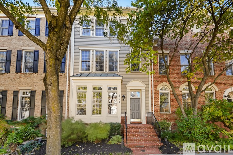 A house with a front yard and a tree in front of it.