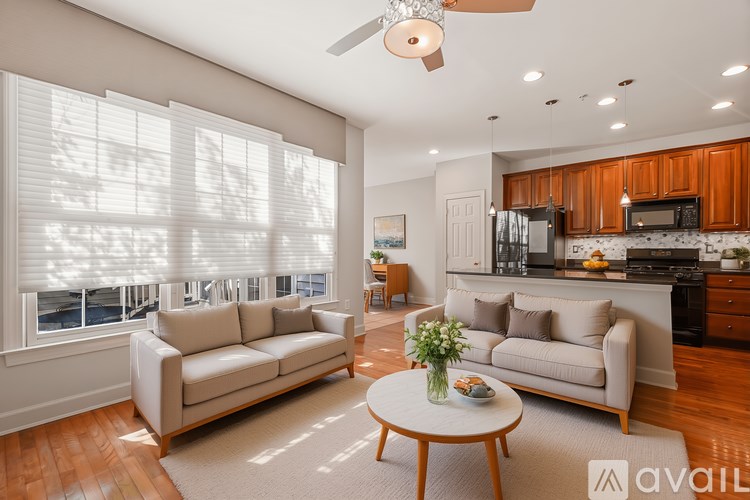 A living room with a couch, a table, and a ceiling fan.