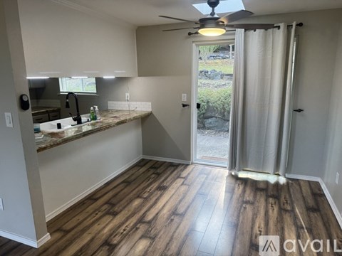 A kitchen with a marble countertop and wooden flooring.