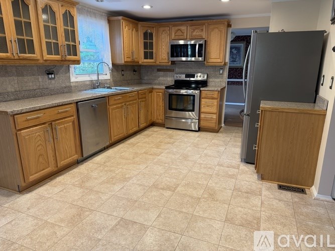 A kitchen with wooden cabinets and a tile floor.