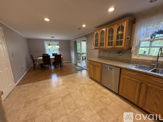 A kitchen with wooden cabinets and a dining table with chairs.
