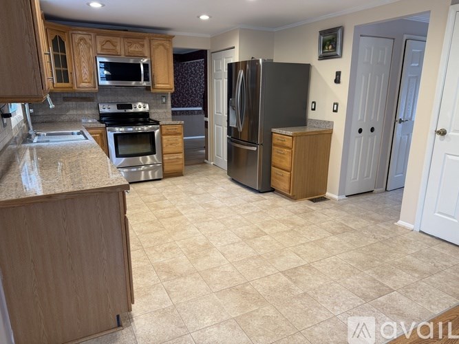 A kitchen with a refrigerator, oven, and microwave.