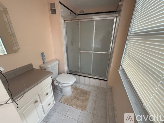 A bathroom with a toilet, sink, and shower.