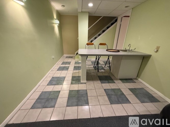 A room with a checkered floor and a table with chairs.