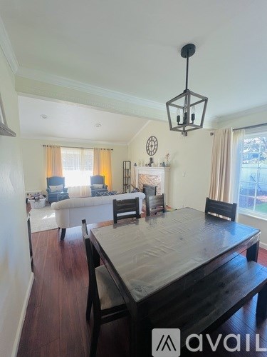 A dining room with a wooden table and chairs.