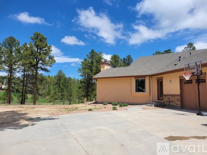 A house with a driveway and trees in the background.