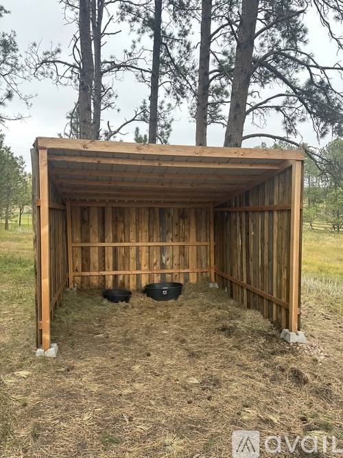 A wooden shelter with two black objects inside.