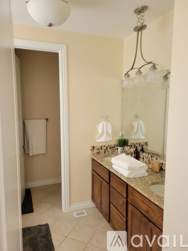 A bathroom with a sink, mirror, and towel.