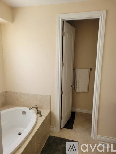 A bathroom with a white bathtub and a white door.