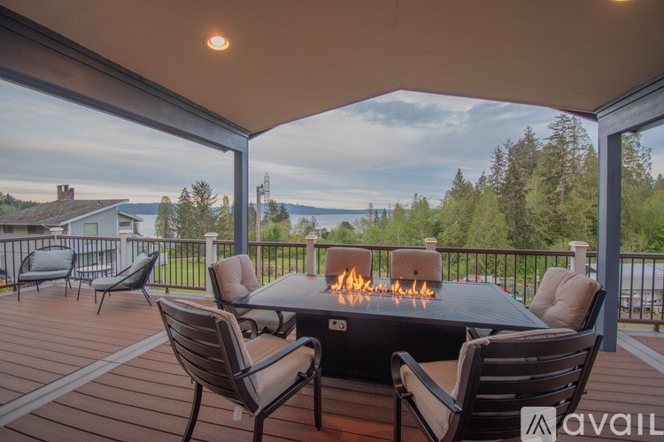 A patio with a table and chairs overlooking a lake.