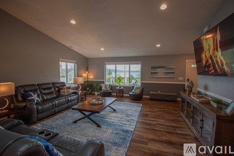 A modern living room with a black leather sofa and a wooden coffee table.
