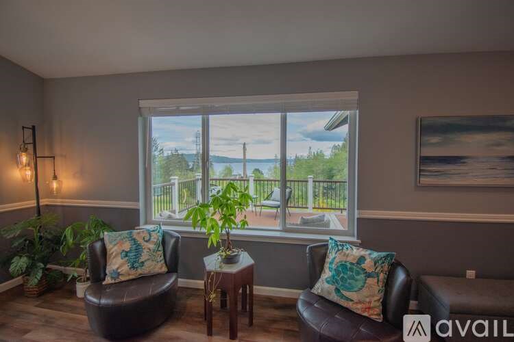 A living room with two chairs and a table with a plant on it.