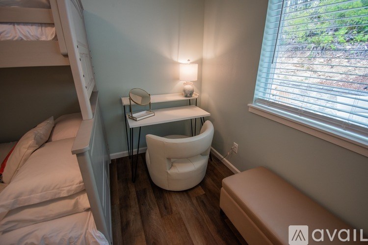 A small room with a bunk bed, a chair, and a desk.