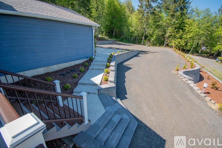 A house with a blue exterior and a driveway leading to the front door.