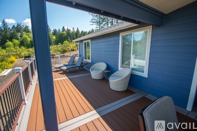 A blue house with a deck and a white chair.