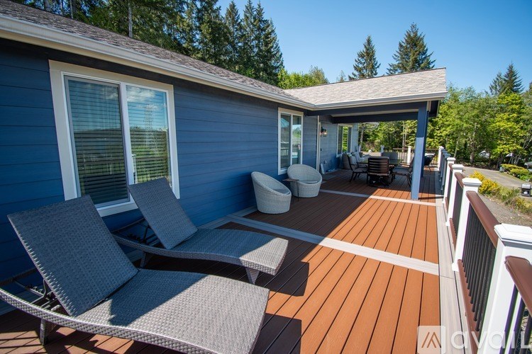 A blue house with a wooden deck and patio furniture.