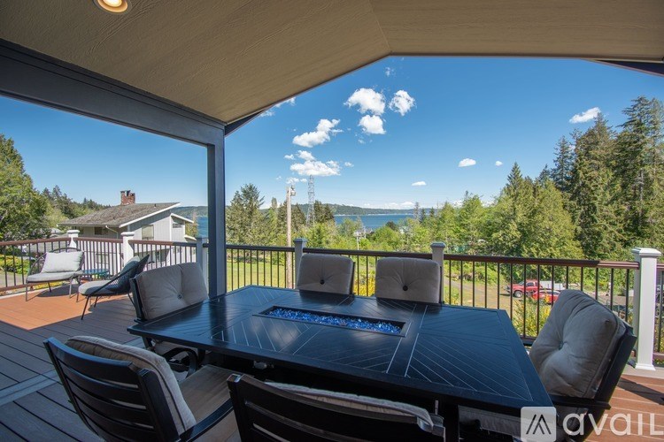 A table with chairs and laptops on a balcony overlooking a lake.