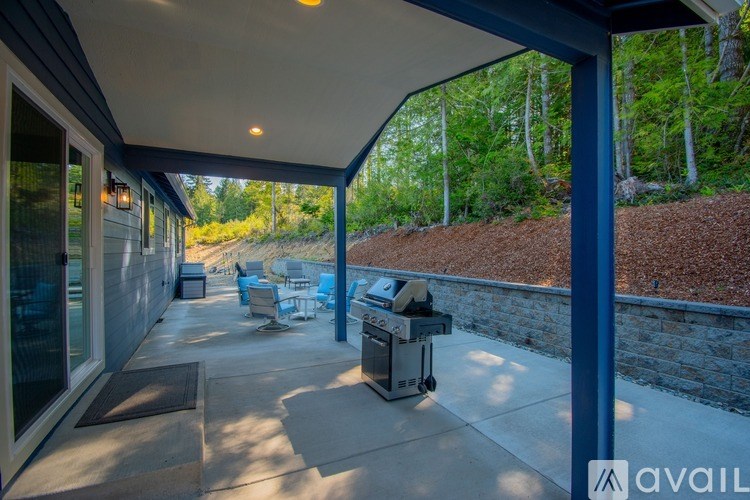 A patio with a table and chairs under a roof.