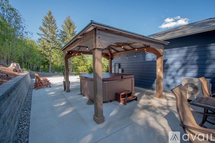 A wooden gazebo with a patio and a grill is available for rent.