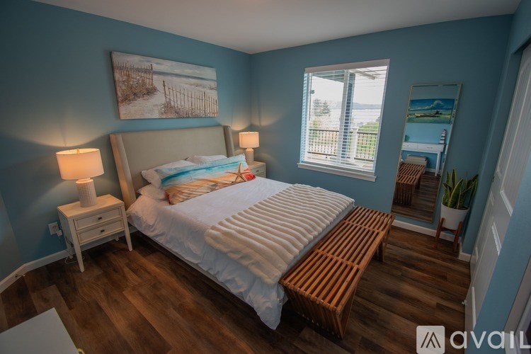 A bedroom with a bed, nightstands, and a window.