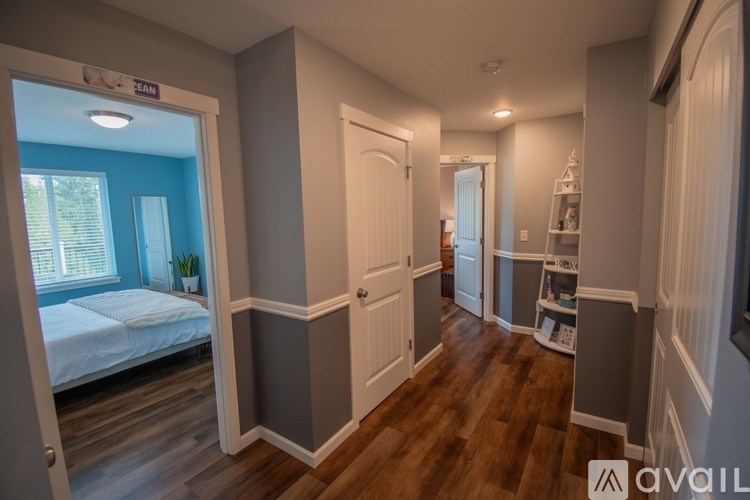 A bedroom with a bed, a window, and a door.