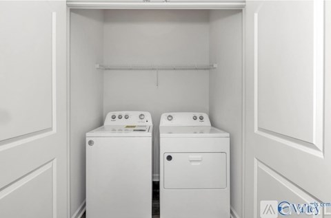 A white laundry room with a washer and dryer.
