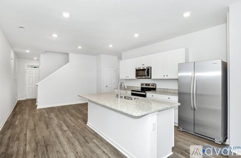 A kitchen with white cabinets and a stainless steel refrigerator.