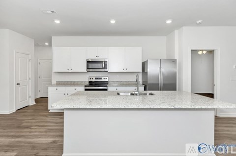 A modern kitchen with white cabinets and a central island.